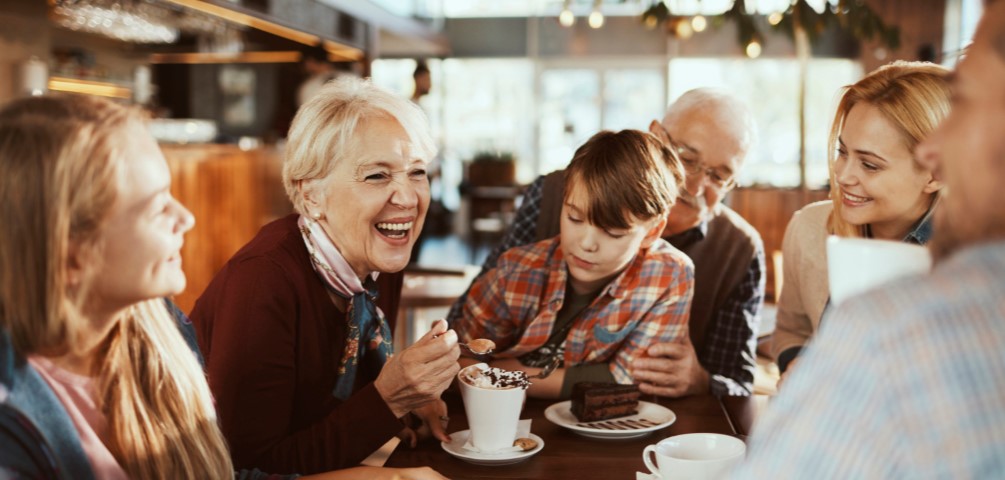family gathered around a table enjoying coffee and hot chocolate