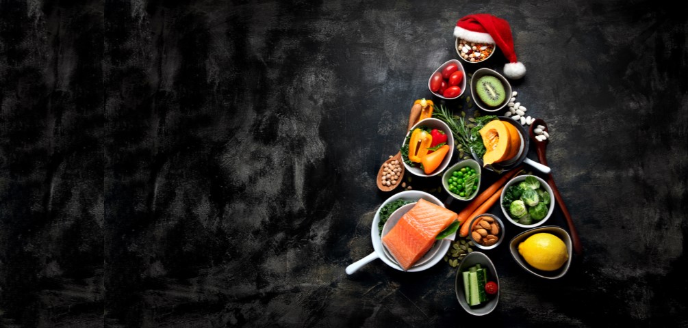 a christmas tree made out of healthy food sits atop a blackboard