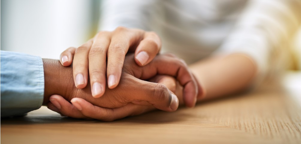 woman holds an older man's hand