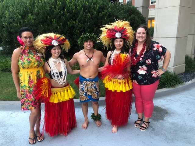A group of happy people at a Hawaiian event share a moment 
