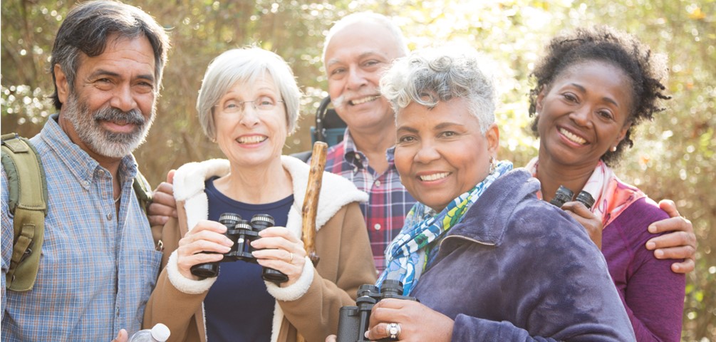 group of older adults gather outside in winter for hiking and birdwatching
