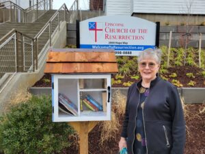 church member stands next to little free library