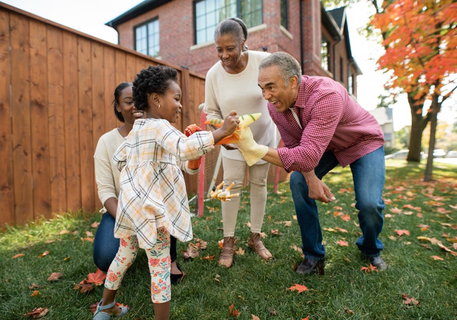 grandfather and grandmother play puppets with grandchildren outside