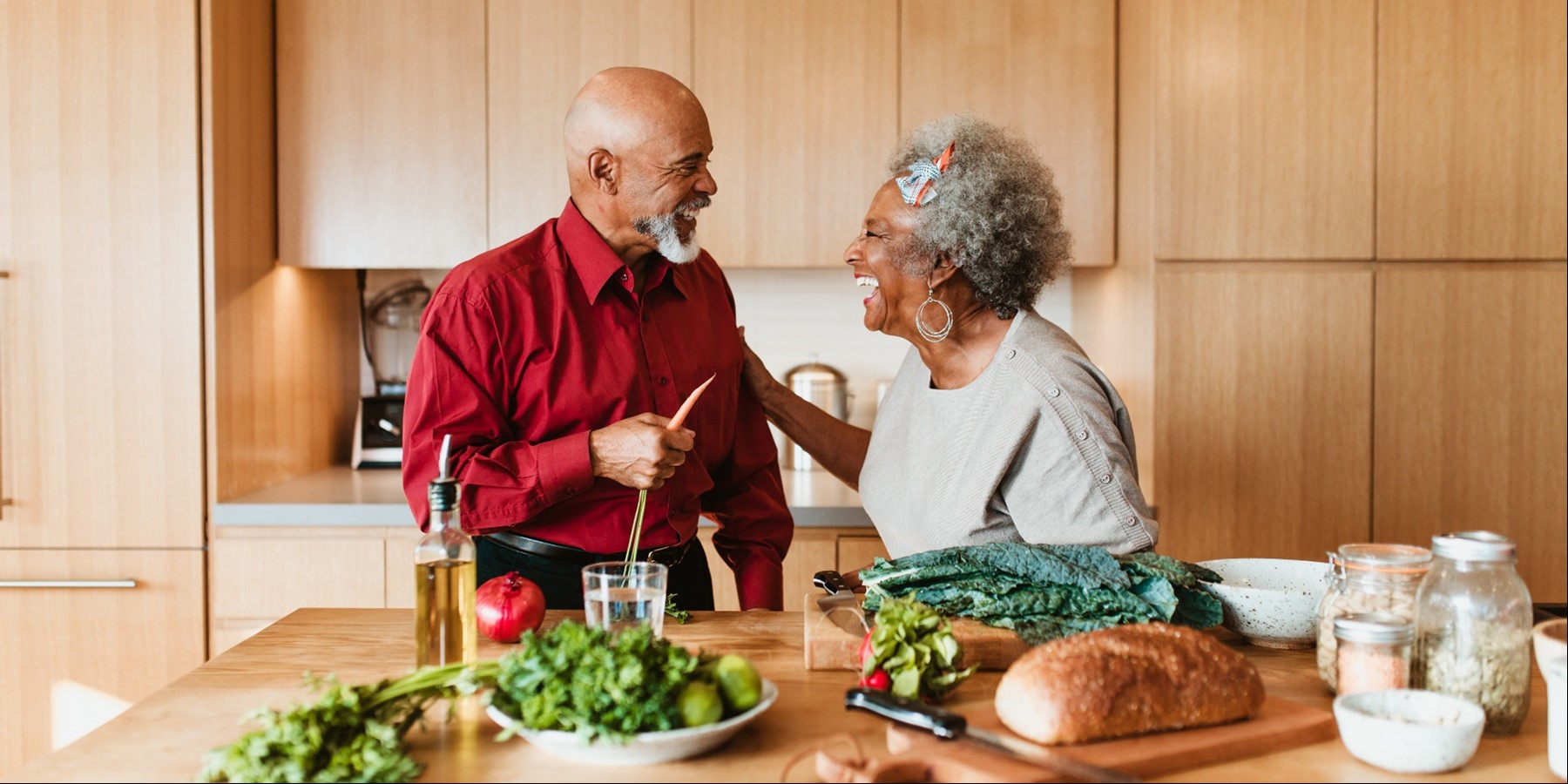 an older couple enjoys cooking together in their kitchen at home