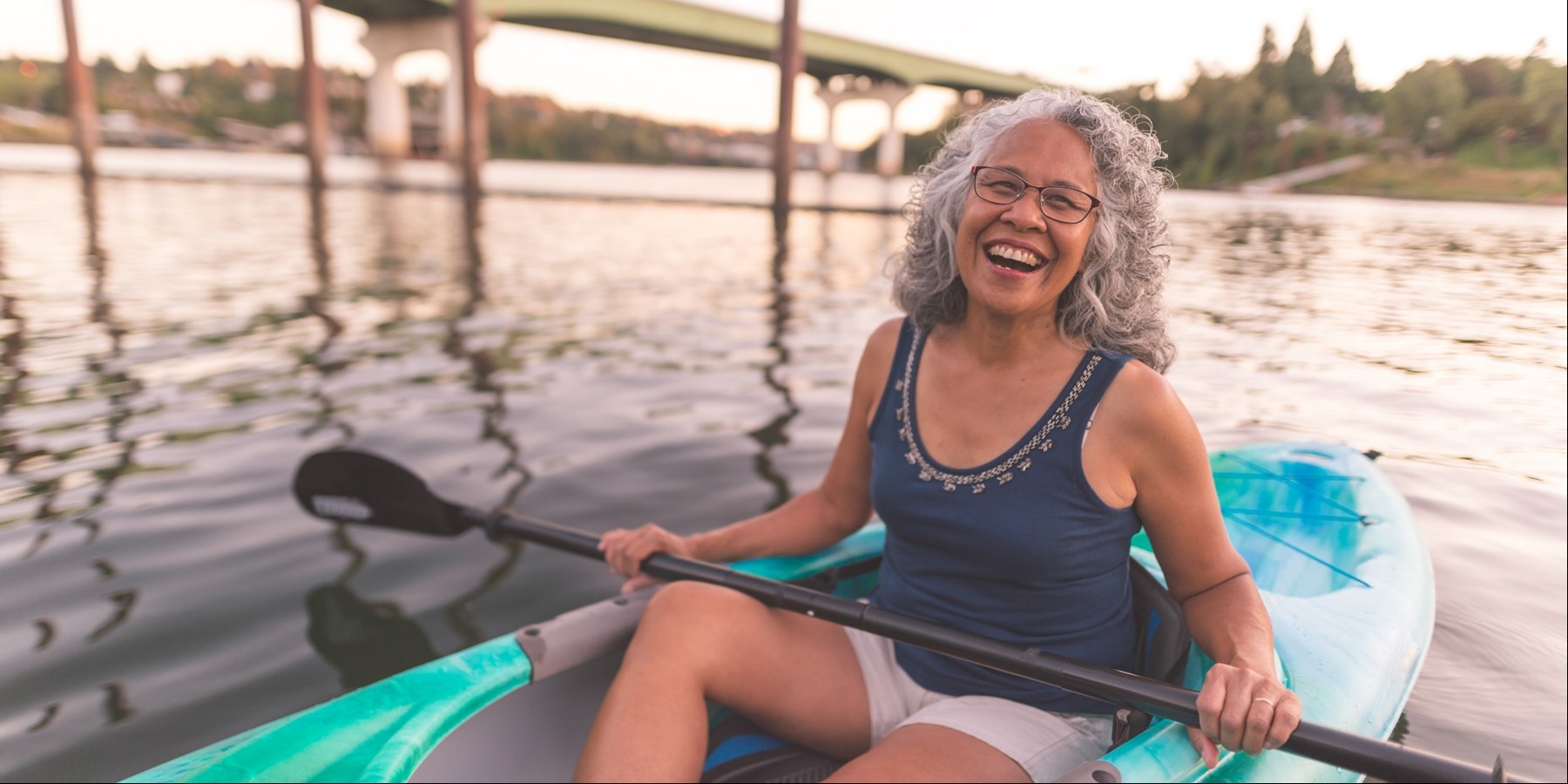 an older adult woman enjoys taking her kayak out on the water