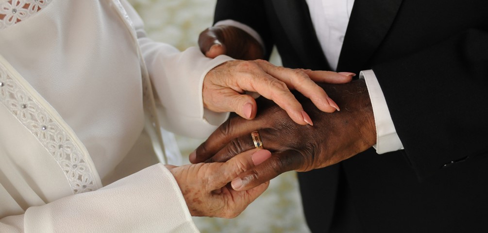 Loving Day. A white woman puts a wedding ring on a black man