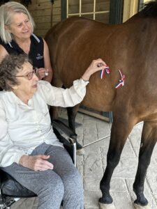 GHBC Resident Betty Allan and Simple Changes Executive Director Corliss Wallingford decorate one of the horses for the 4th of July.