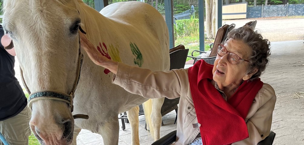 GHBC Resident Betty Allan participates in horse finger painting during an Equine Assisted Learning session at Simple Changes.