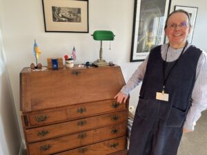 Resident Candace Kent poses next to a vintage secretary desk