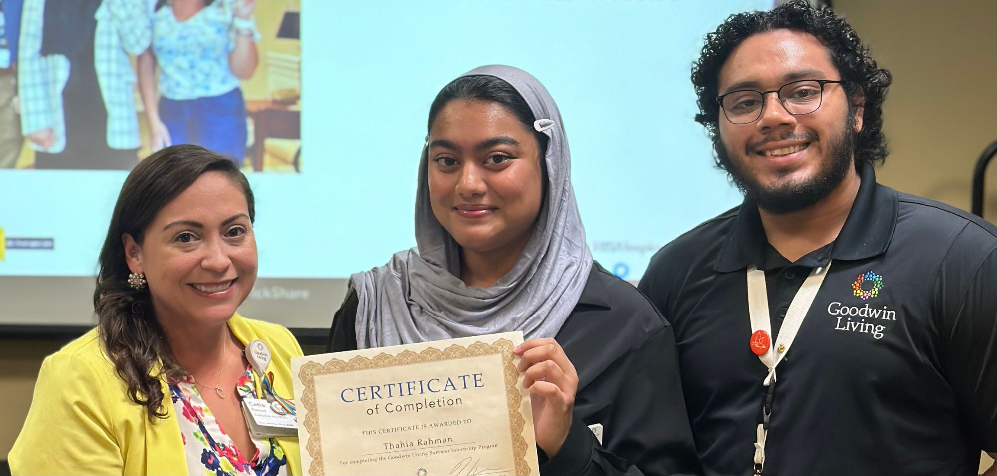 intern Thahia Rahman holds a certificate as she stands between her two supervisors