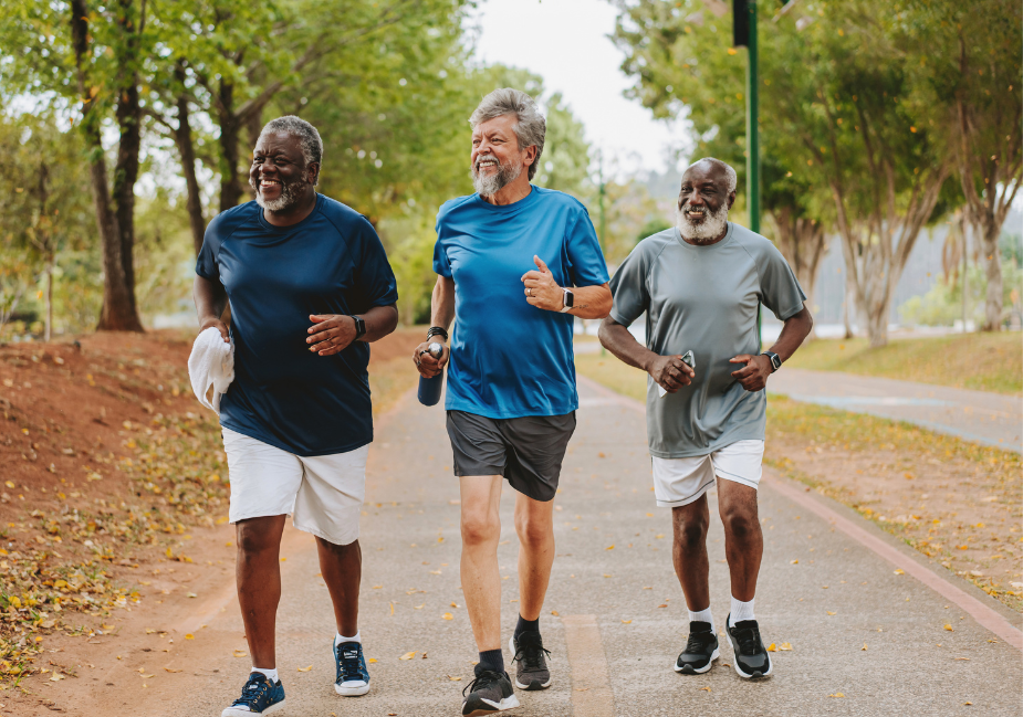 three older adult men in t-shirts and shorts running for exercise outside