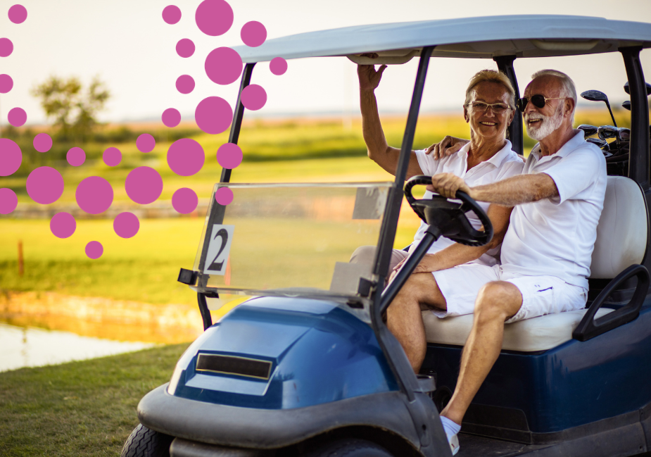 a senior couple ride in a golf cart on the golf course